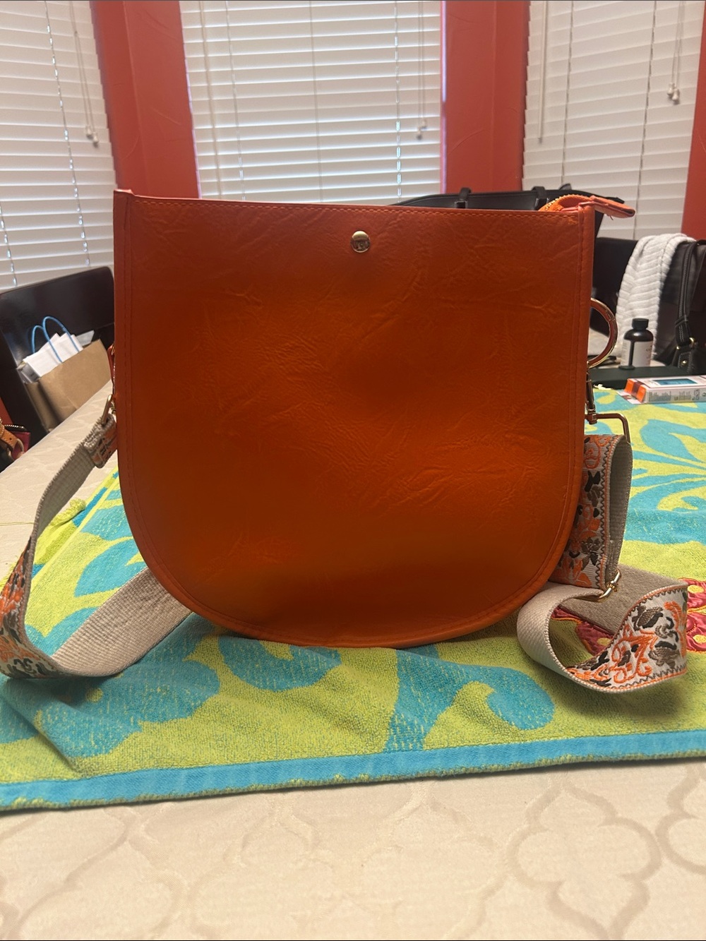 Vibrant Orange Crossbody Saddle Bag with Patterned Strap